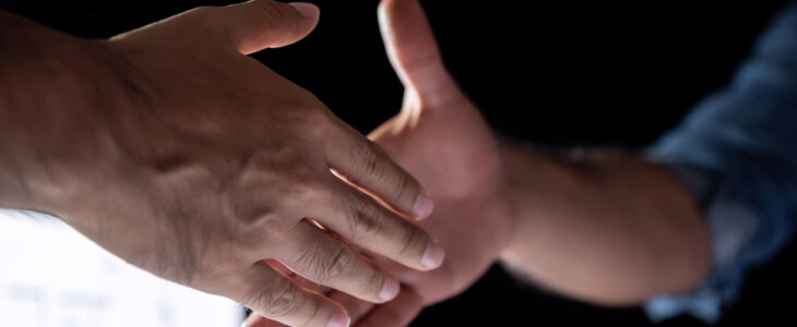 Businessmen reaching out for a handshake agreement during late night work in the office