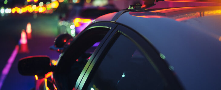 A police car stopping a vehicle at night.