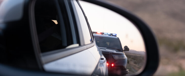 View from the passenger seat rear view mirror of getting pulled over by a police car
