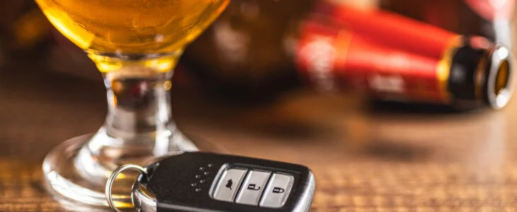 Car key with beer glass on a wooden table. Booze driving concept. Drunk driver concept.